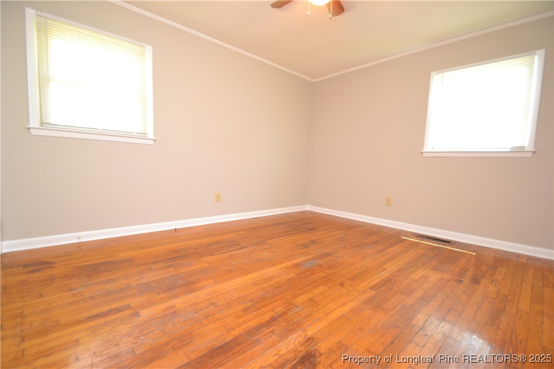 717 Friar Tuck Road Raleigh, NC 27610 - Photo 22 of 31 an empty room with wooden floor and windows