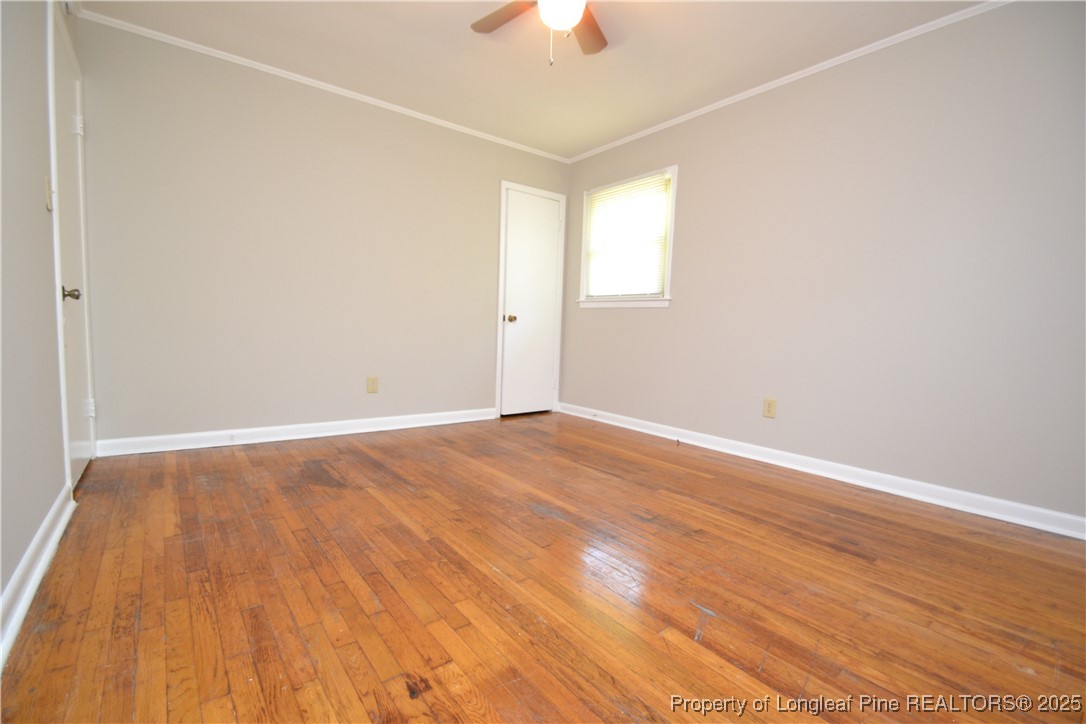 717 Friar Tuck Road Raleigh, NC 27610 - Photo 23 of 31 an empty room with wooden floor chandelier fan and windows