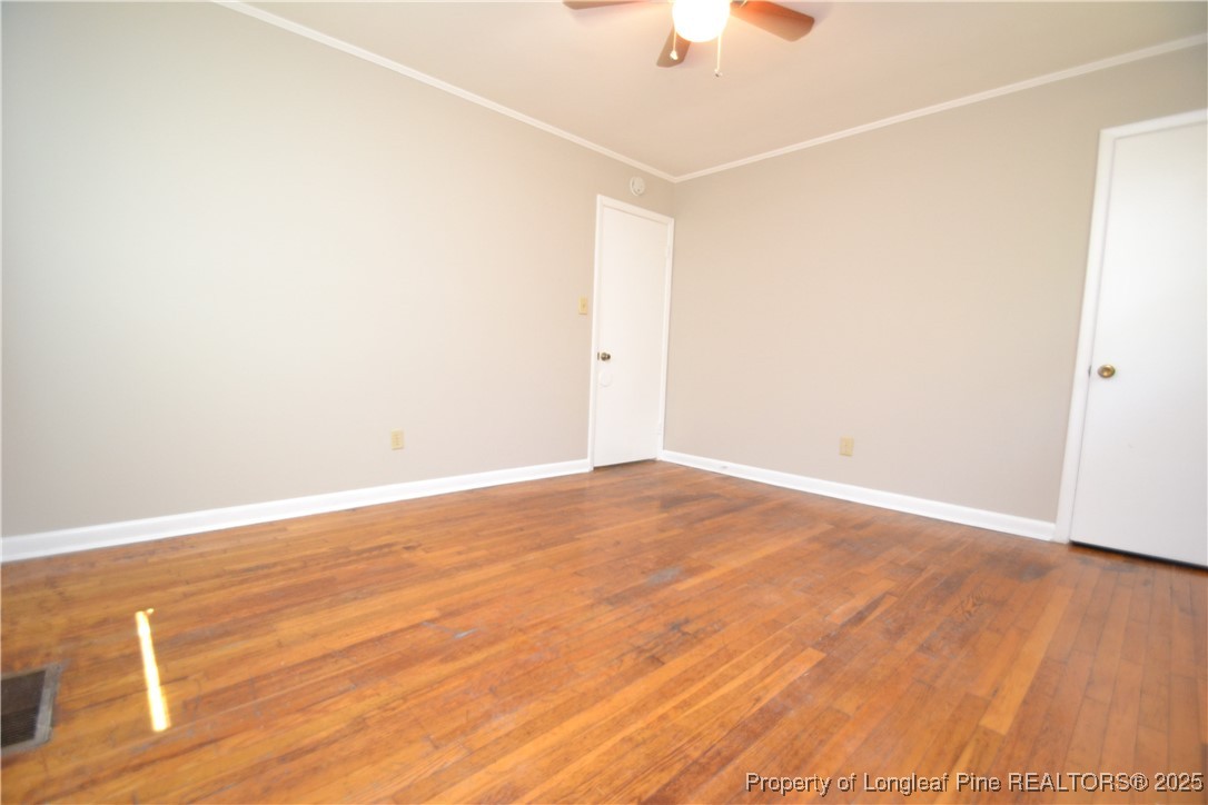 717 Friar Tuck Road Raleigh, NC 27610 - Photo 24 of 31 an empty room with wooden floor and fan