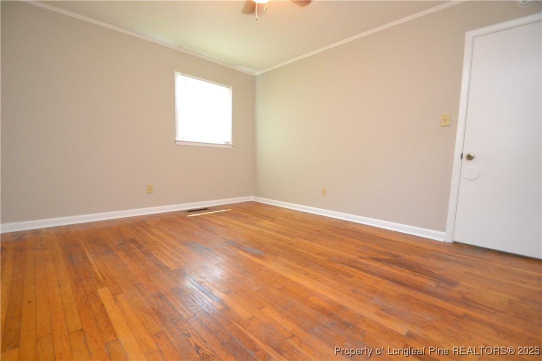 717 Friar Tuck Road Raleigh, NC 27610 - Photo 25 of 31 an empty room with wooden floor and windows