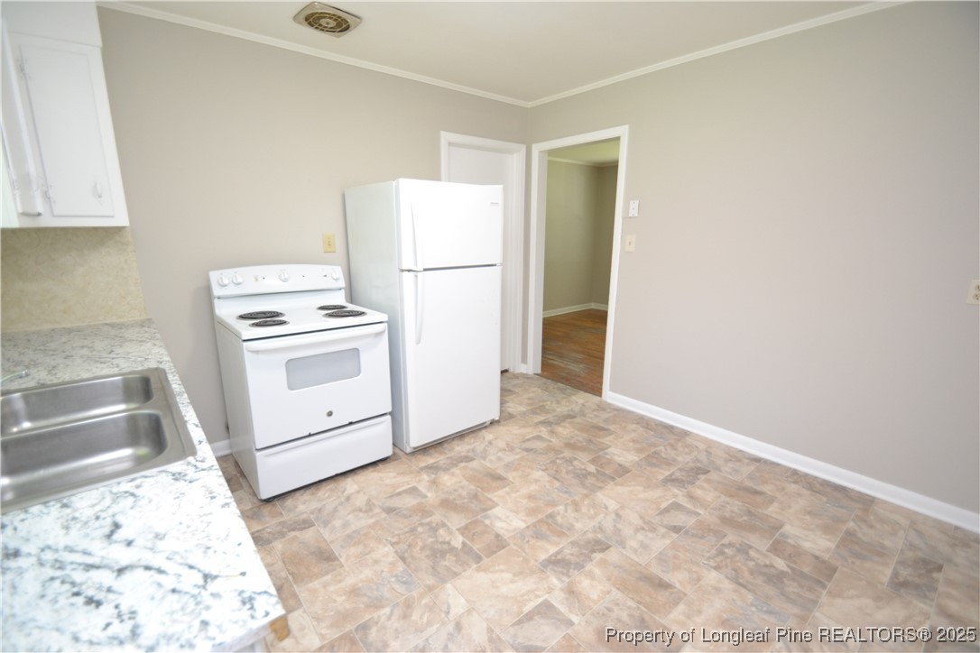 717 Friar Tuck Road Raleigh, NC 27610 - Photo 8 of 31 a kitchen with a stove top oven and cabinets