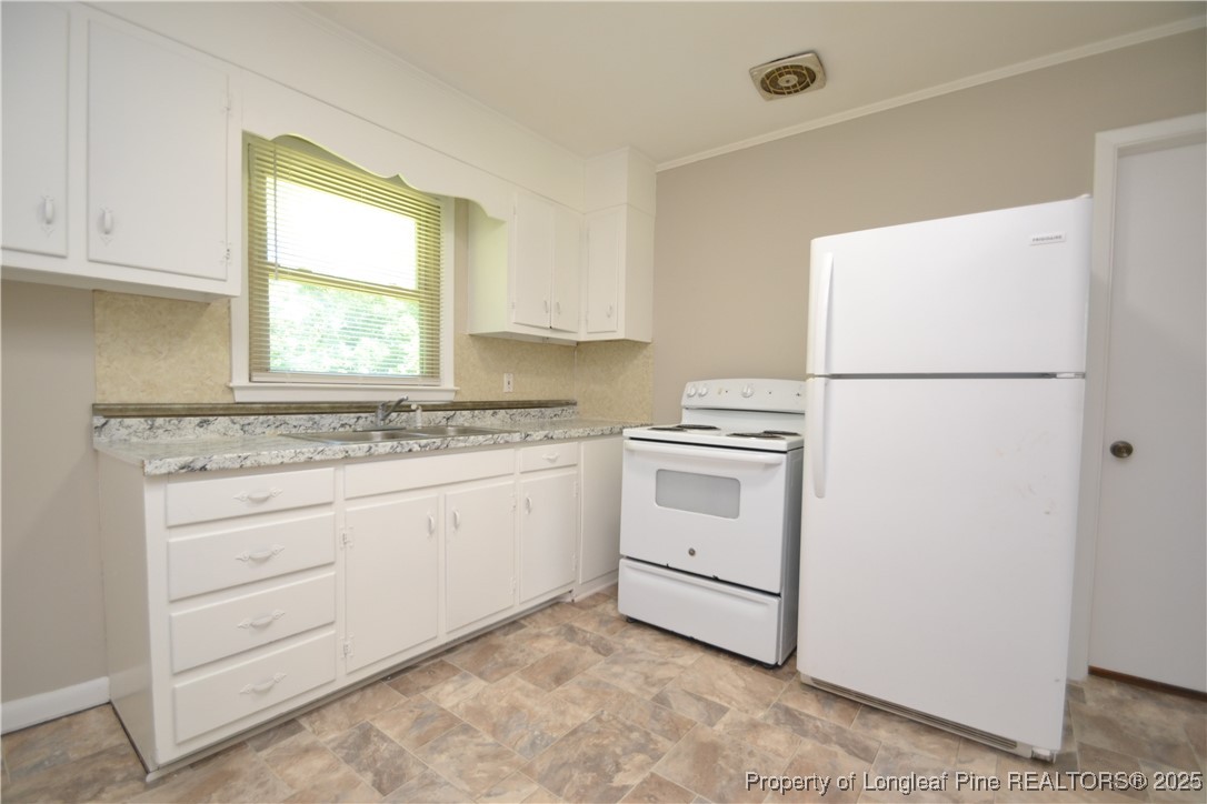 717 Friar Tuck Road Raleigh, NC 27610 - Photo 10 of 31 a kitchen with granite countertop cabinets appliances a sink and a window