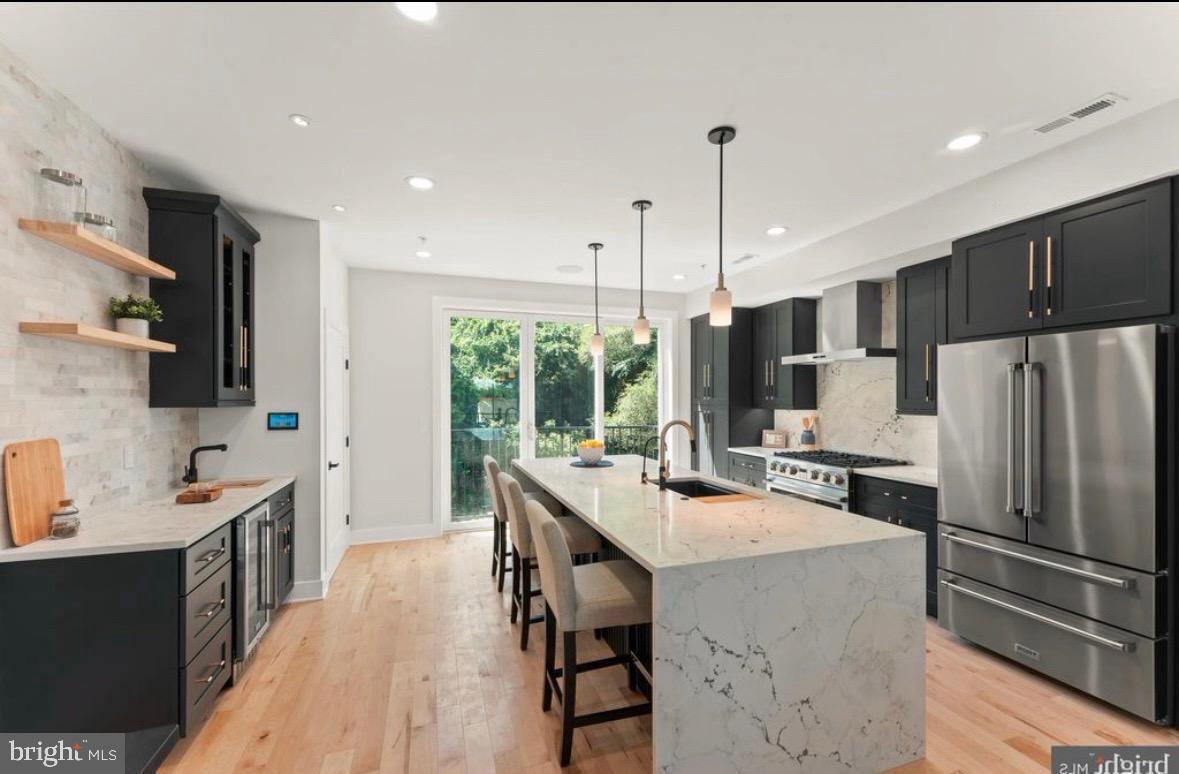 6983 Silverwood Street Philadelphia, PA 19128 - Photo 13 of 18 a kitchen with stainless steel appliances a stove refrigerator sink cabinets dining table and chairs