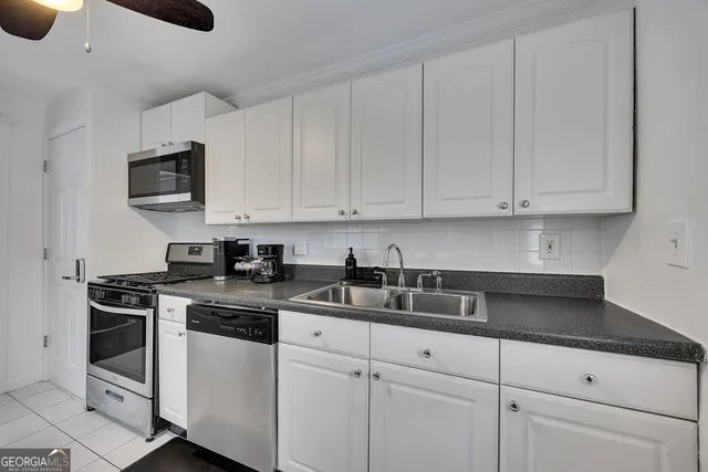 a kitchen with white cabinets and a stove top oven