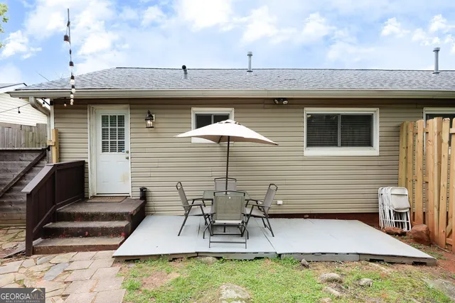 a view of a patio with table and chairs with wooden floor and fence