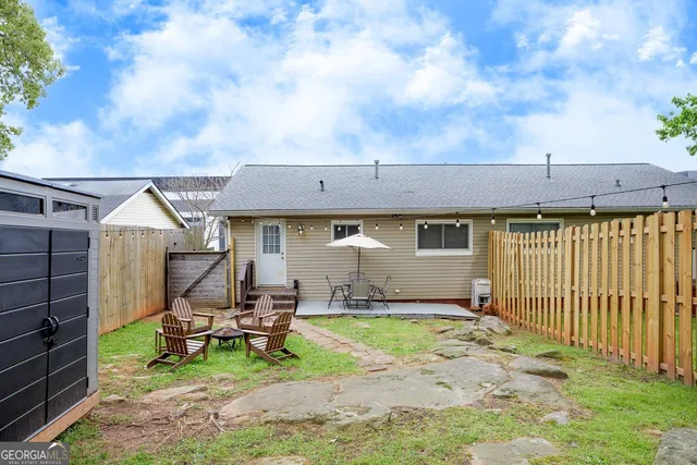 a view of a house with backyard and sitting area