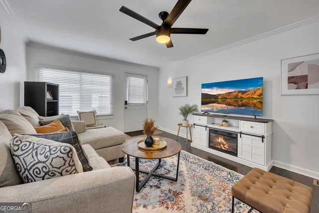 a living room with furniture a flat screen tv and a table
