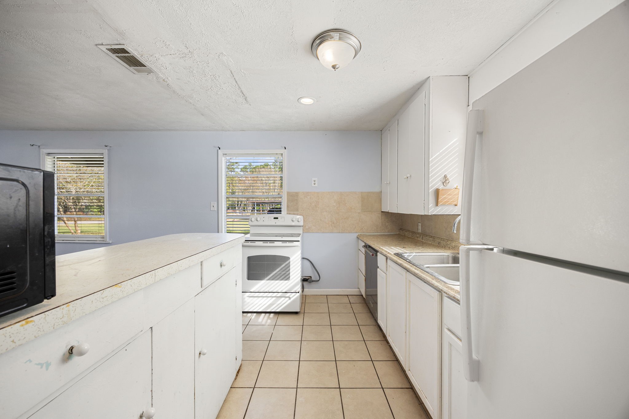 340 Magnolia Drive Houston, TX 77336 - Photo 21 of 48 a kitchen with white cabinets and white appliances