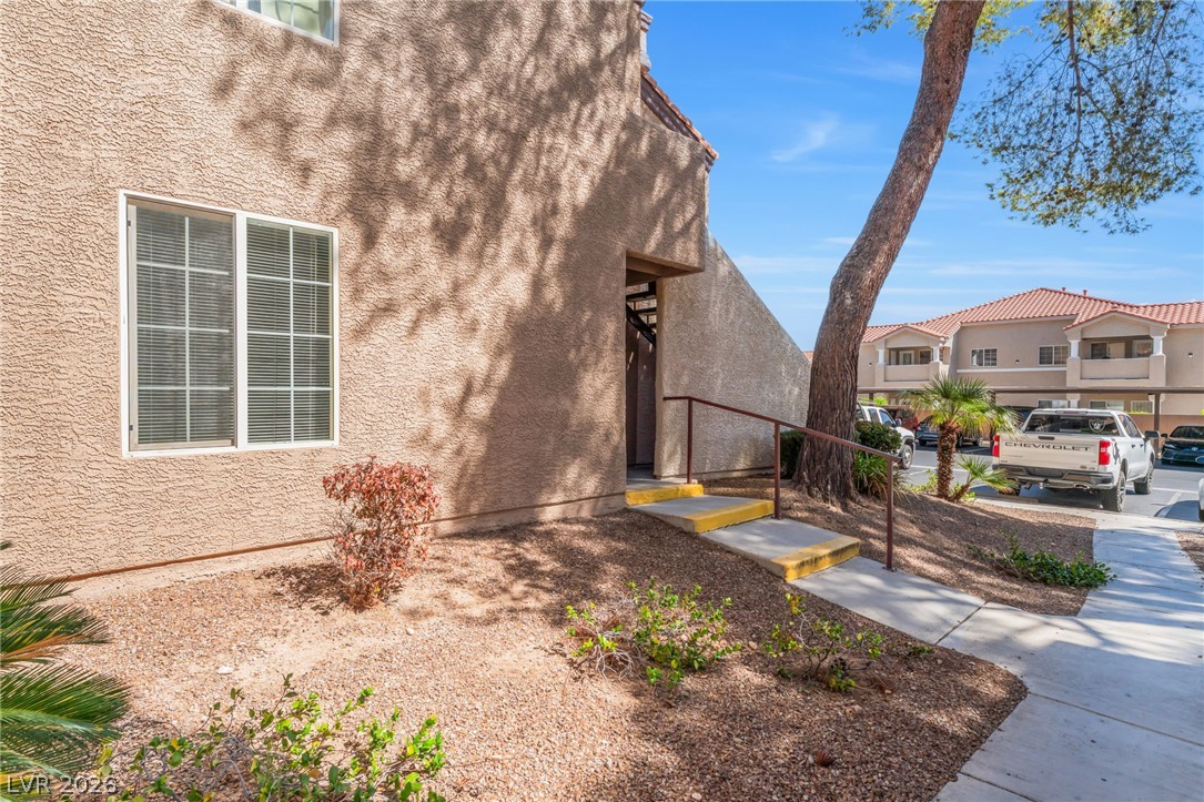 9325 West Desert Inn Road, Unit 177 Las Vegas, NV 89117 - Photo 2 of 24 A concrete path with handrails leads to the private entrance of this stucco home.