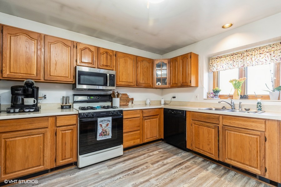 2808 Tahoe Lane Spring Grove, IL 60081 - Photo 7 of 21 a kitchen with stainless steel appliances granite countertop wooden cabinets a sink and a stove