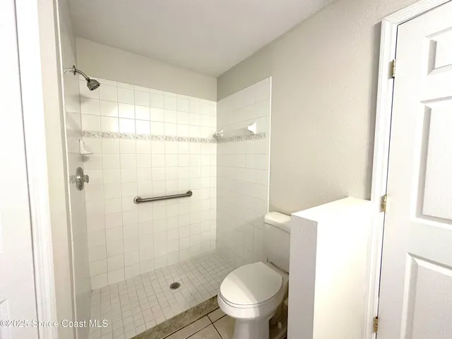 a bathroom with a shower a toilet and a window