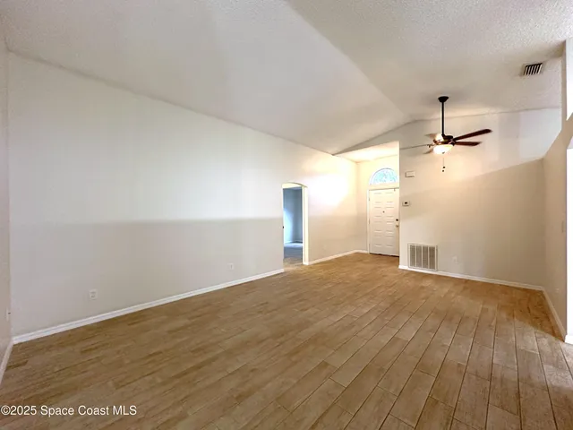 a view of empty room with wooden floor