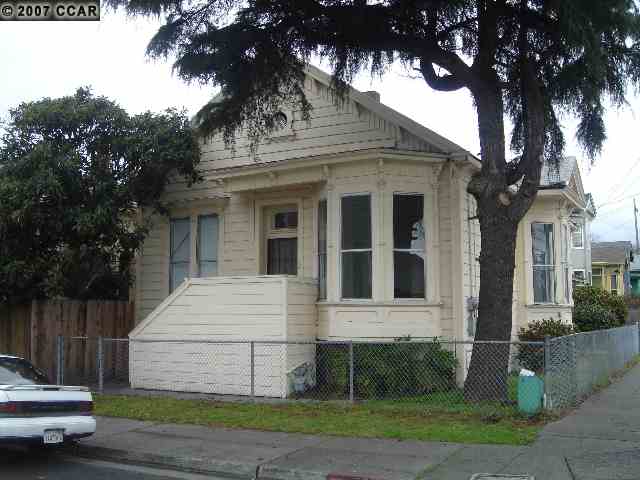 a view of a white house with a large tree