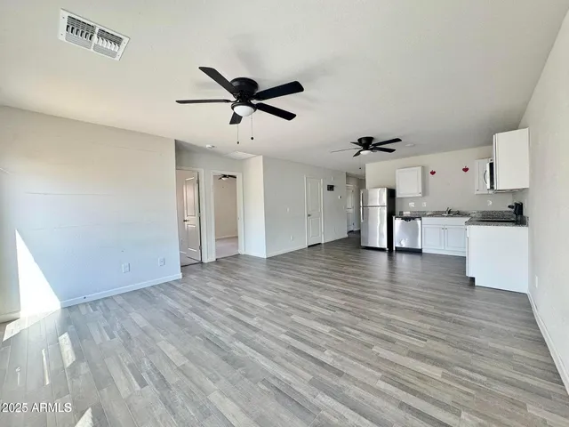 a view of a kitchen with wooden floor and a ceiling fan