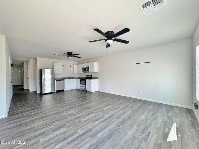 a view of a livingroom with a hardwood floor and a ceiling fan