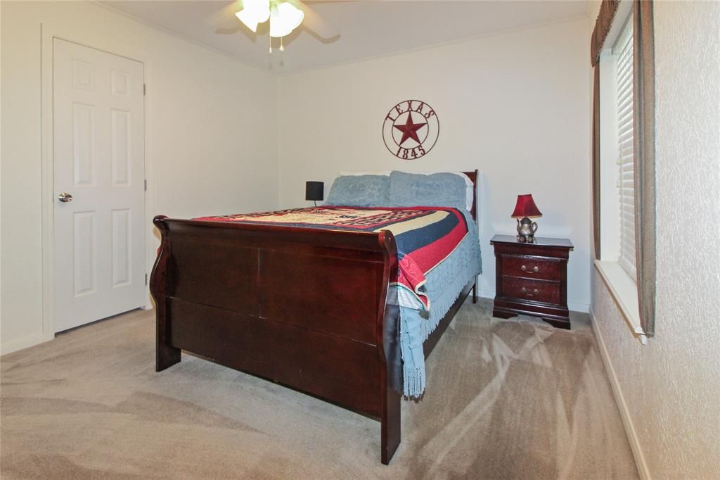 455 Hughes Cemetery Road Italy, TX 76651 - Photo 19 of 40 a bedroom with a bed and a chandelier