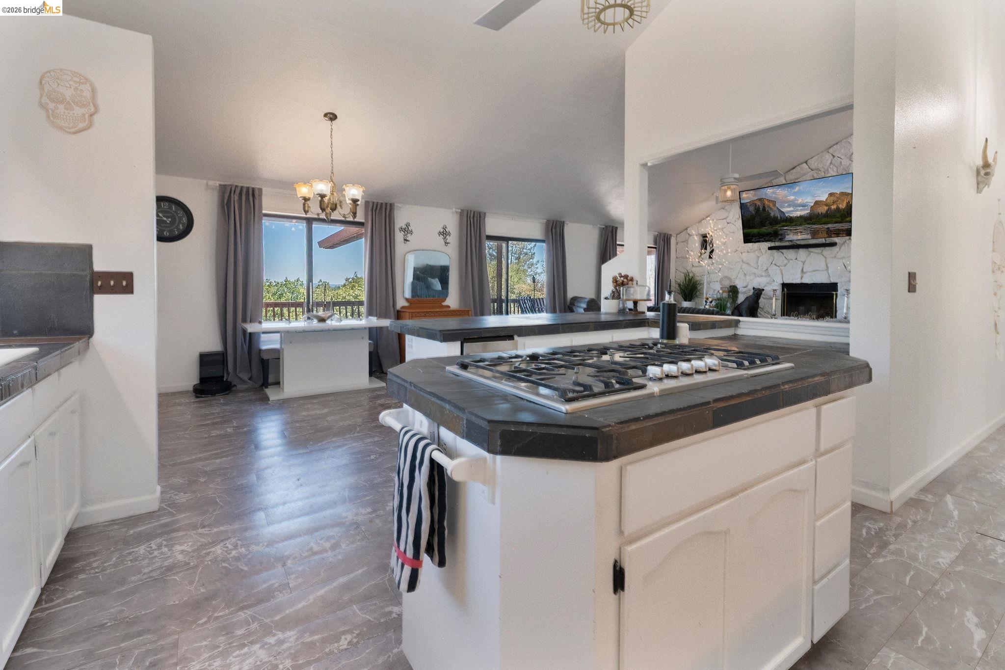 22963 Robertson Ranch Road Sonora, CA 95370 - Photo 18 of 90 Kitchen island featuring a gas cooktop and dark tile countertop