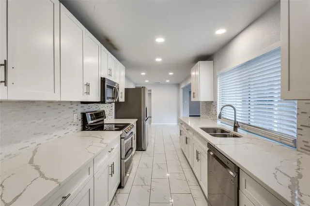 a kitchen with stainless steel appliances granite countertop a sink stove and refrigerator