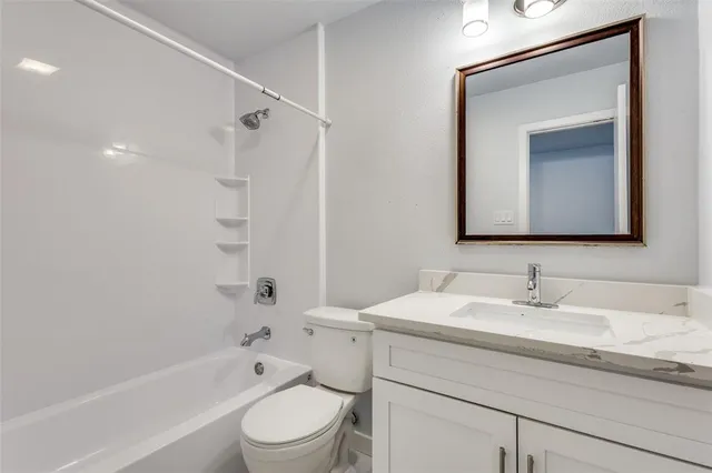 a bathroom with a toilet sink vanity tub and shower