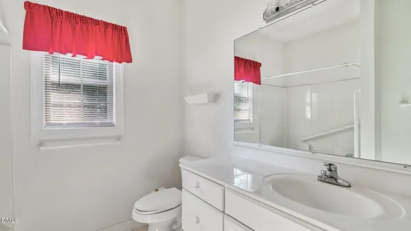 a bathroom with a sink vanity mirror and toilet