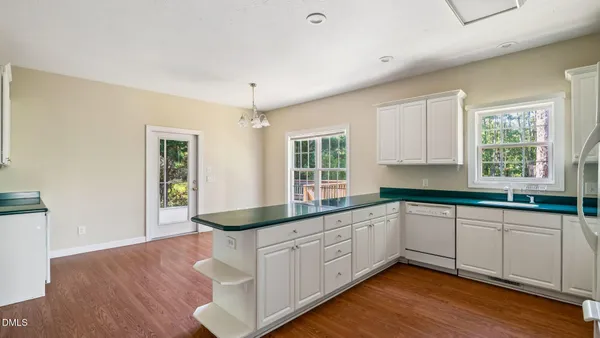 a kitchen with sink cabinets and wooden floor