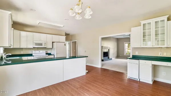 a kitchen with stainless steel appliances granite countertop a sink cabinets and wooden floor
