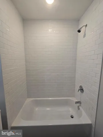 a bathroom with a bathtub a sink a toilet and a mirror