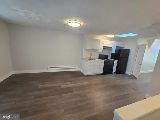 a view of a kitchen with furniture and wooden floor