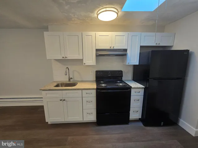 a view of a kitchen with a sink and a refrigerator