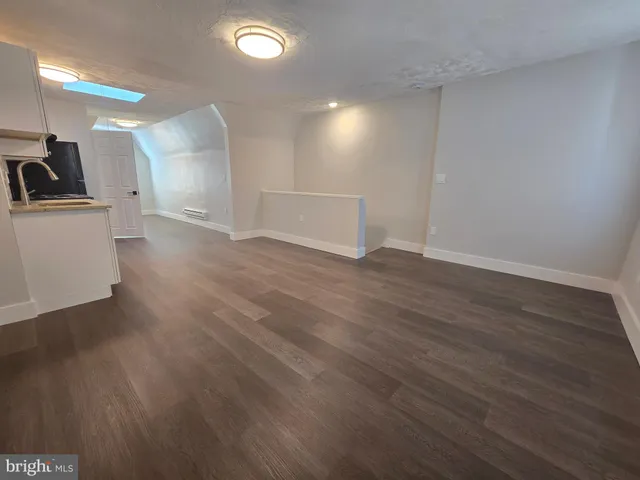 a white toilet sitting next to a white sink and vanity