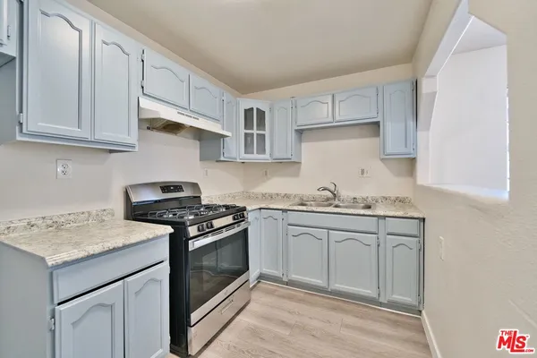a kitchen with granite countertop white cabinets and white appliances