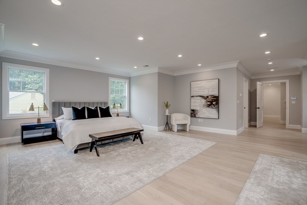 68 Clarke Circle Needham, MA 02492 - Photo 26 of 40 a spacious bedroom with a bed a table and a large window