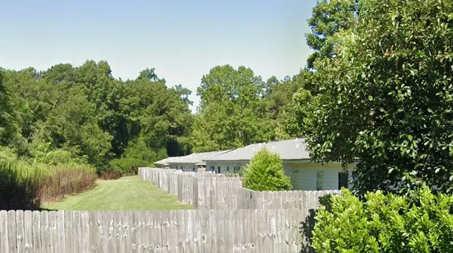 a wooden fence with trees in the background