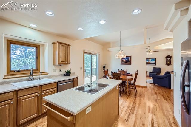 3715 Range View Road Monument, CO 80132 - Photo 12 of 49 Kitchen featuring appliances with stainless steel finishes, light hardwood / wood-style flooring, sink with a view to the backyard and a center island.