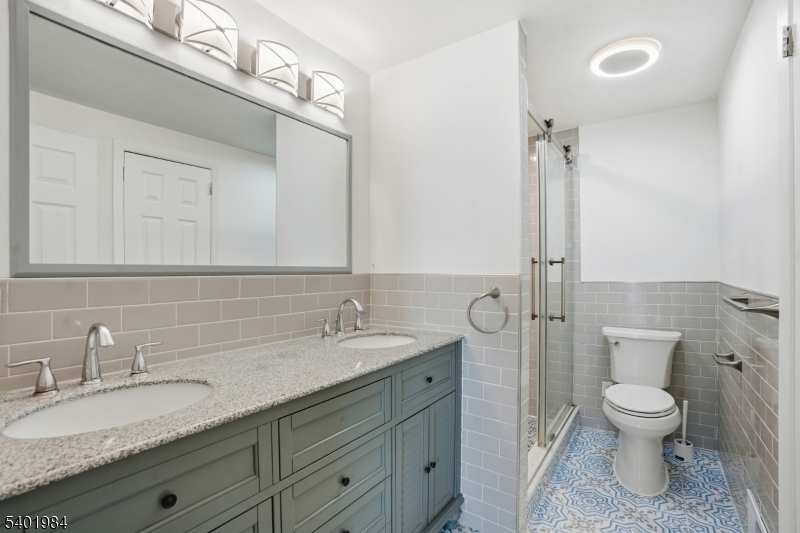 95 Martin Road Livingston, NJ 07039 - Photo 17 of 26 a bathroom with a granite countertop sink a toilet and a mirror