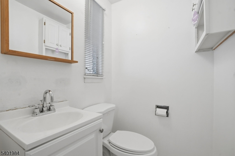 95 Martin Road Livingston, NJ 07039 - Photo 25 of 26 a bathroom with a toilet a sink and mirror
