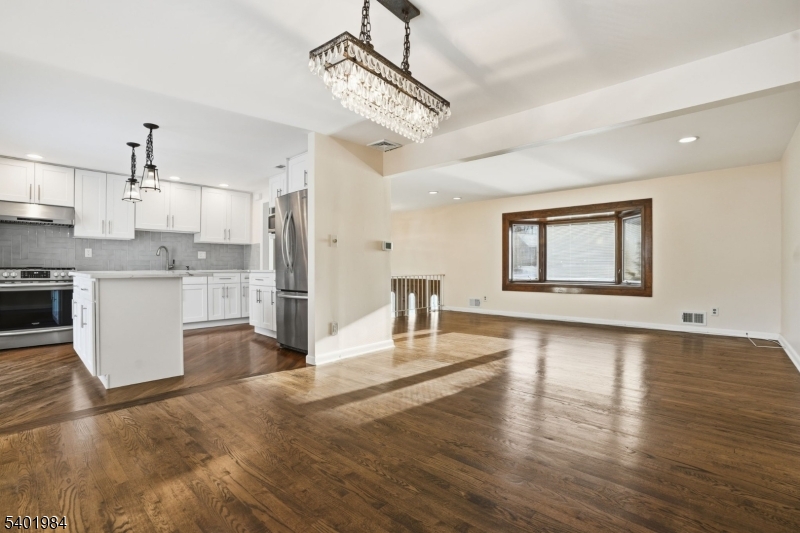 95 Martin Road Livingston, NJ 07039 - Photo 3 of 26 a view of a kitchen with kitchen island a sink wooden floor and a refrigerator