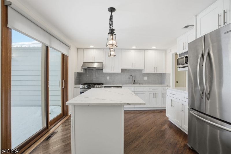 95 Martin Road Livingston, NJ 07039 - Photo 4 of 26 a kitchen with stainless steel appliances granite countertop a refrigerator a sink and white cabinets