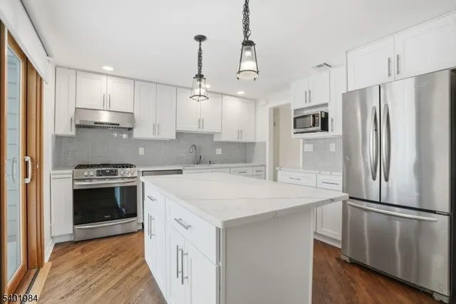 a kitchen with stainless steel appliances a refrigerator sink and stove