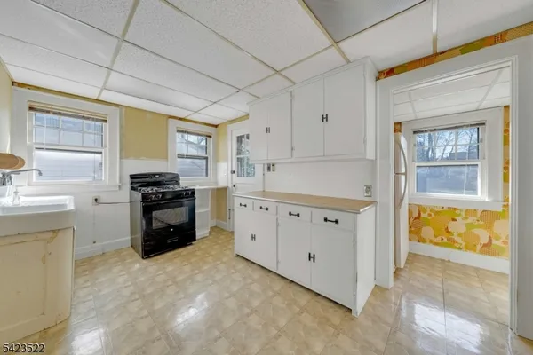 a view of a hallway to a room with wooden floor and a bathroom