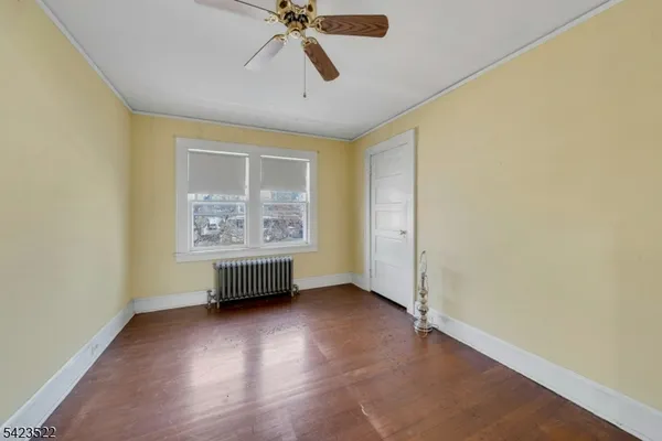 a view of empty room with wooden floor and fireplace