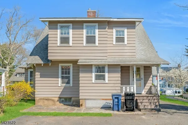 a front view of a house with a garden and plants