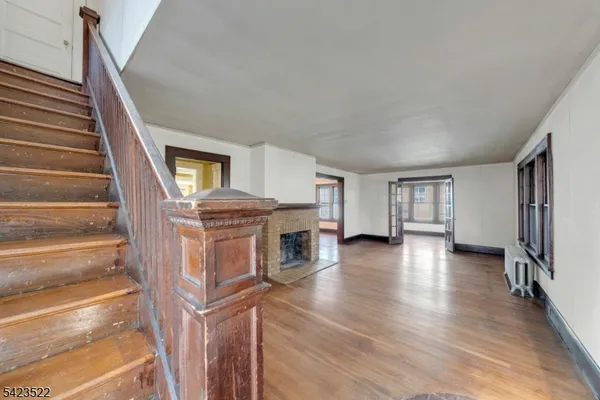 a view of a livingroom with wooden floor and staircase