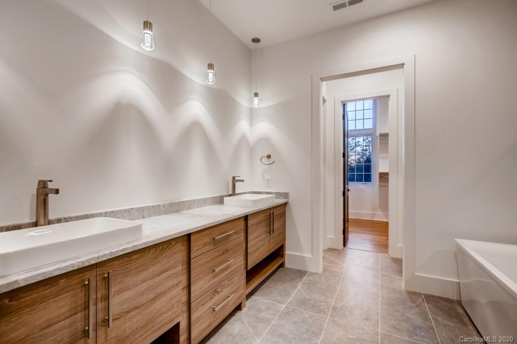 1104 Vision Path Concord, NC 28027 - Photo 15 of 28 a spacious bathroom with a granite countertop sink a toilet a mirror and shower