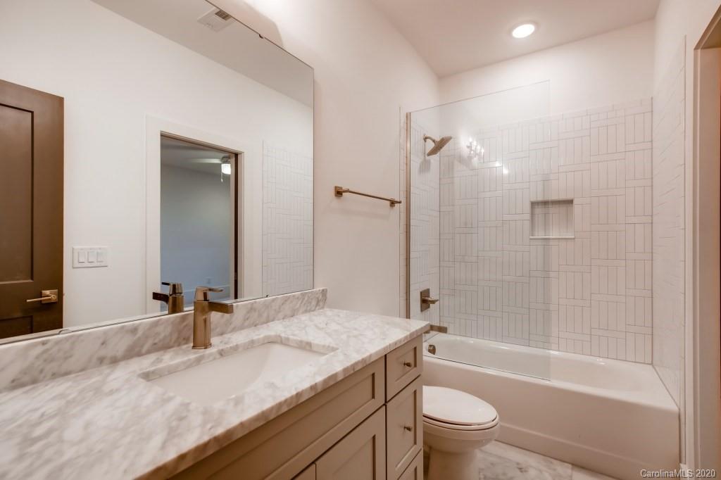 1104 Vision Path Concord, NC 28027 - Photo 23 of 28 a bathroom with a granite countertop sink a toilet and shower