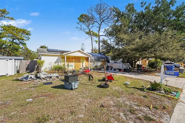 a backyard of a house with table and chairs plants