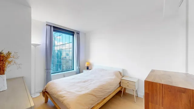 a bed sitting in a bedroom next to a window