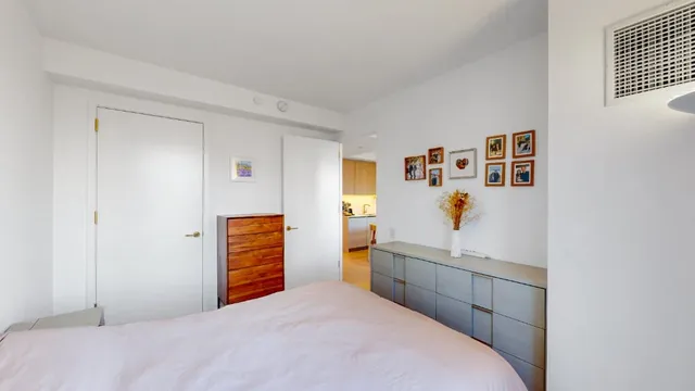 a bedroom with a bed and a painting on the wall