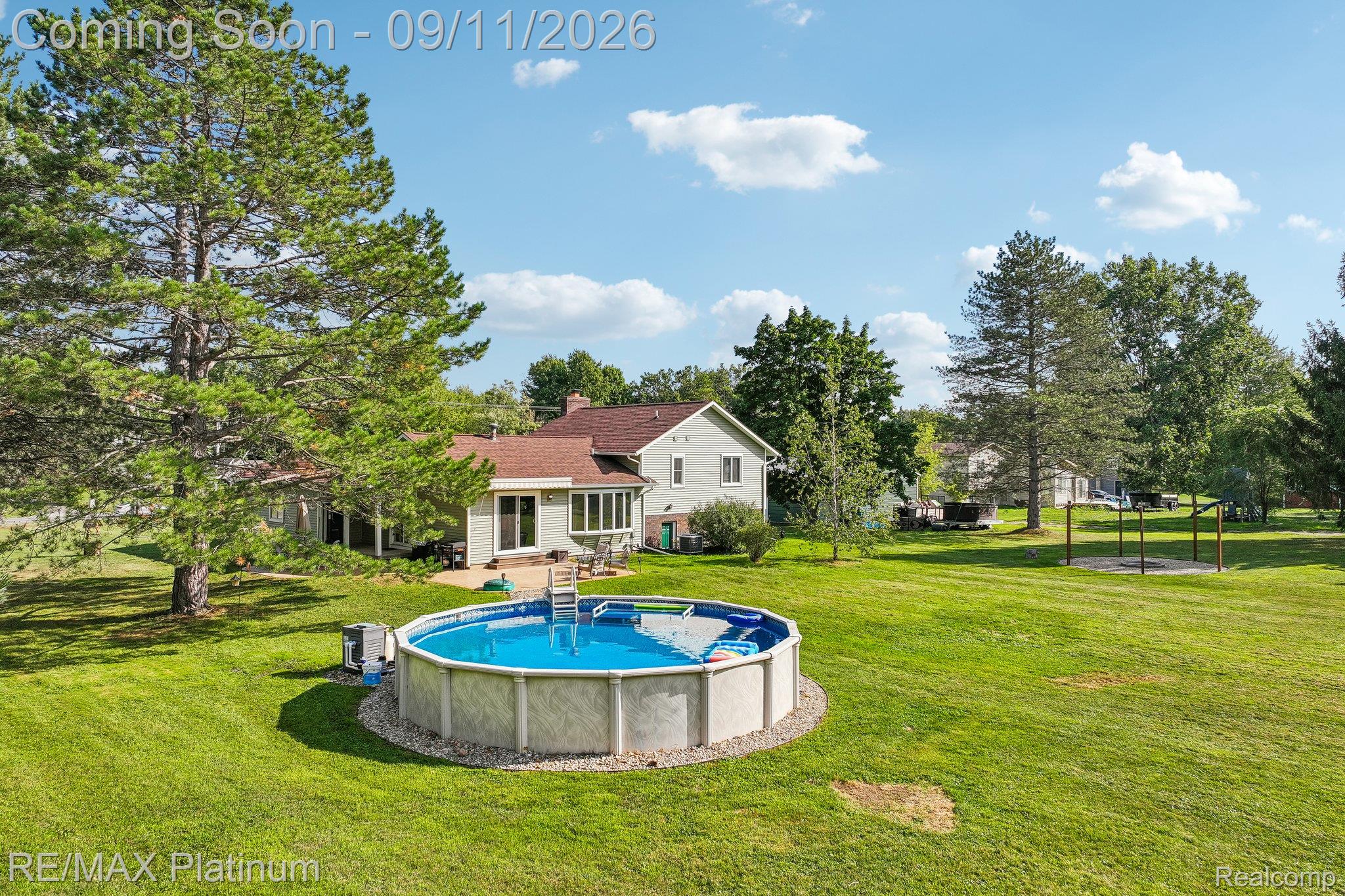 12126 Linden Road Linden, MI 48451 - Photo 27 of 38 Expansive backyard featuring a large above-ground pool, patio area, and mature trees