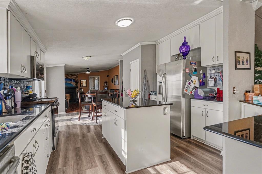 21664 Highway 34 Terrell, TX 75161 - Photo 14 of 34 a kitchen with stainless steel appliances kitchen island granite countertop a refrigerator and a stove top oven